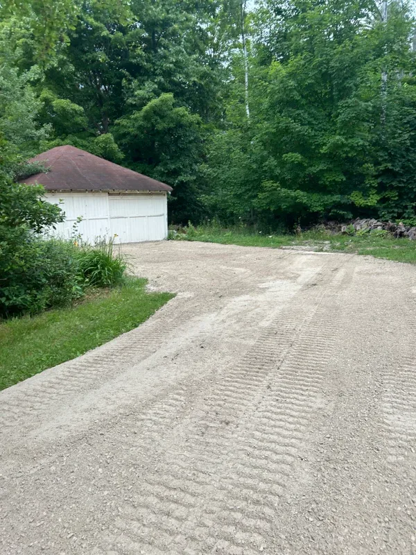 Freshly graded gravel drive beside a shed