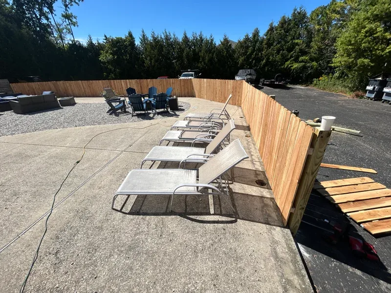 Cedar privacy fence beside a patio with lounge chairs