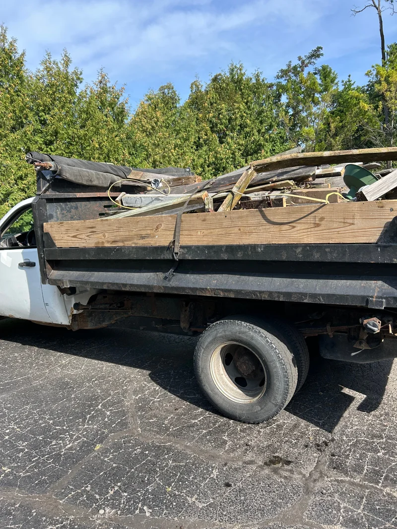 Dump truck loaded with lumber and salvaged debris for hauling